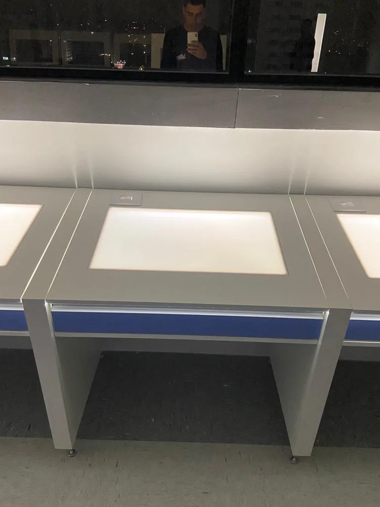Detalhe da mesa de inspeção com tampo luminoso e tomada