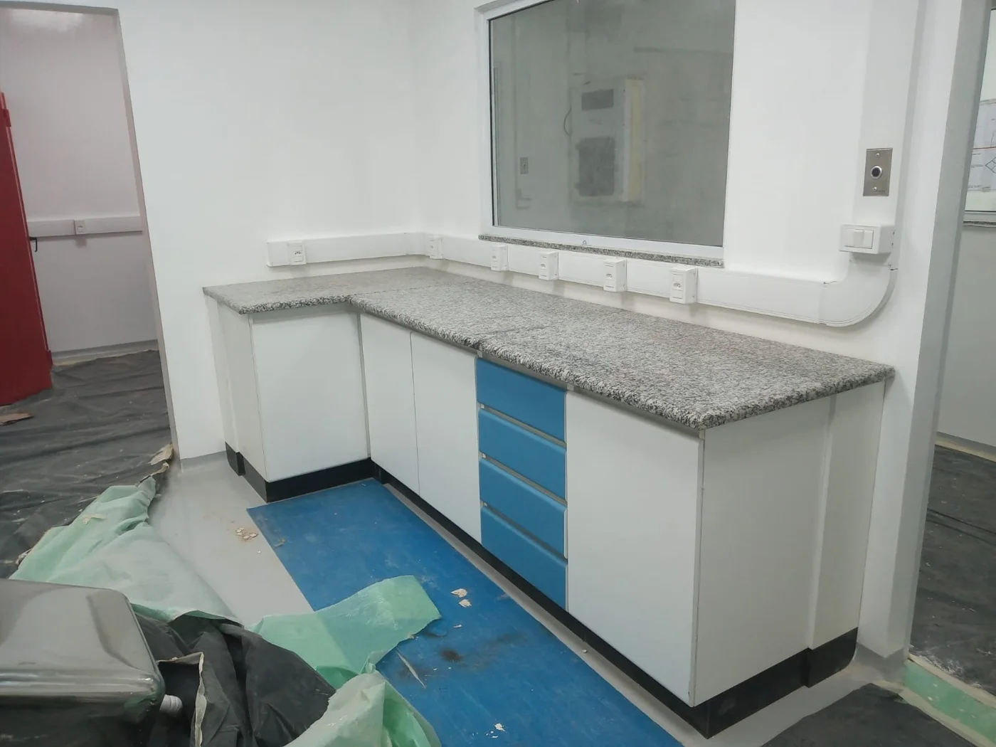 Bancada em L com gavetas azuis e tampo em granito